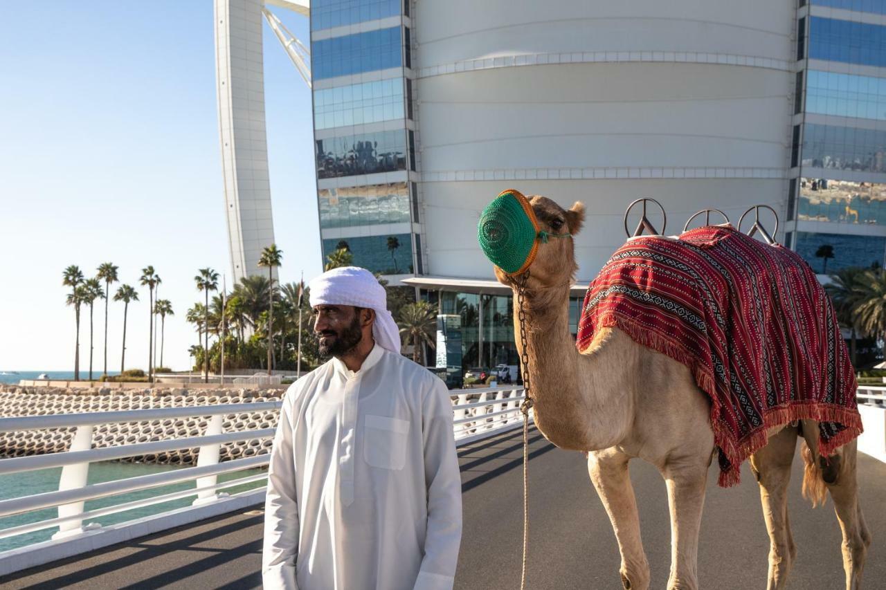 Burj Al Arab Jumeirah Dubai Exterior foto A man with a camel in Doha, Qatar
